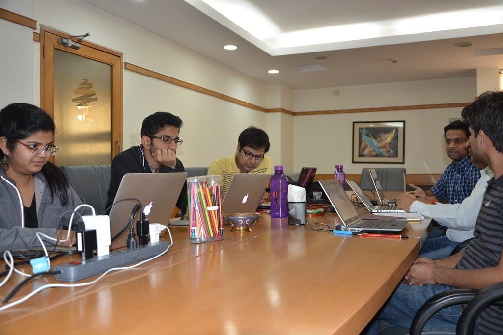 Adults working on laptops around a table at a hands-on workshop